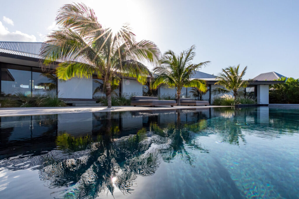 Pool reflecting the modern villa and palms, Villa Valentina, St. Barts.
