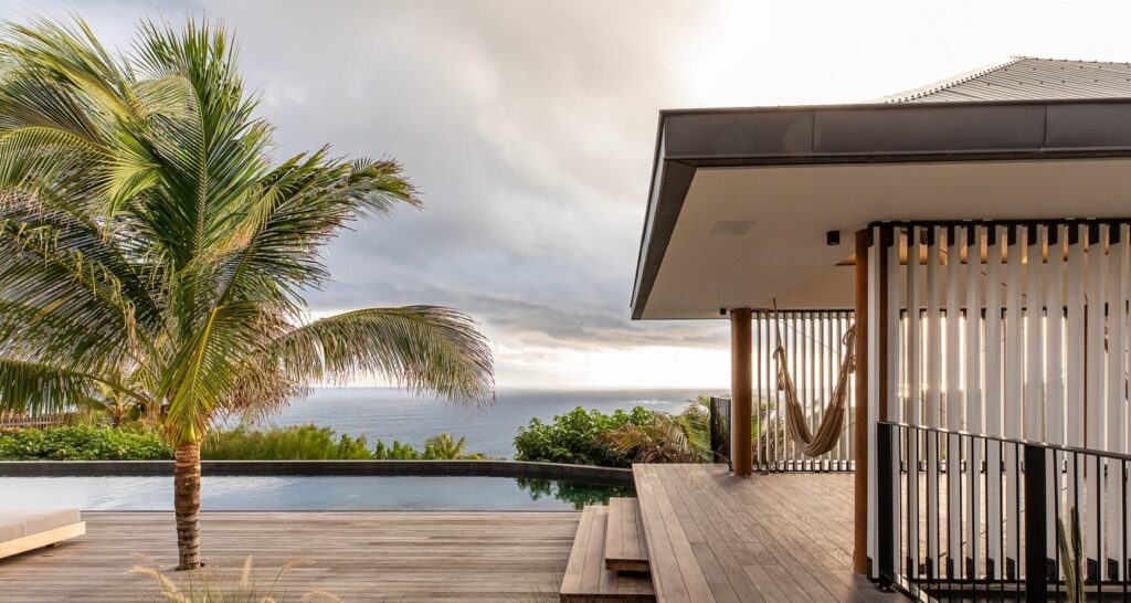 Ocean-view terrace with infinity pool, covered pavilion, hammock, and palm on the deck, Villa Valentina, St. Barts.