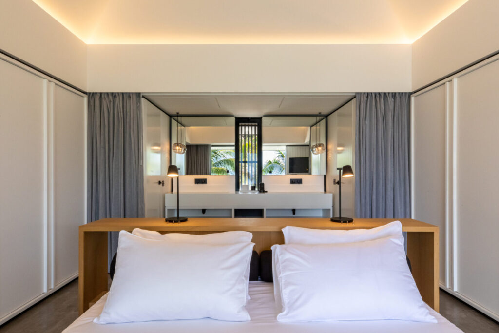 Villa Valentina, St. Barts: white bed and wood headboard wall toward a bright ensuite
